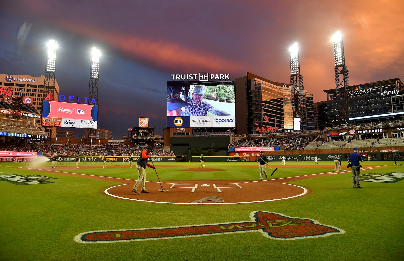 Grounds crew members prepare the field after a rain delay during game two of the National League Division Series baseball game between the Braves and the Phillies at Truist Park in Atlanta on Wednesday, October 12, 2022. (Hyosub Shin / Hyosub.Shin@ajc.com)