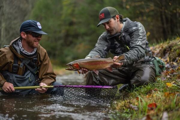 Charles Warren, who left a consulting job to start Wood Valley Travel & Media, holds a fish caught by one of his clients. 
Courtesy of Wood Valley Travel & Media / Will Taylor.