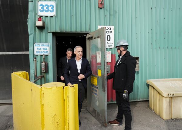 Canadian Prime Minister designate Mark Carney, left, leaves after he tours the ArcelorMittal Dofasco steel plant in Hamilton, Ont., on Wednesday, March 12, 2025. (Nathan Denette /The Canadian Press via AP)