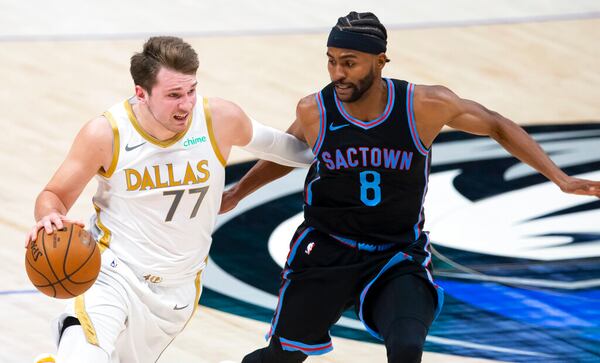 Dallas Mavericks guard Luka Doncic, left, battles Sacramento Kings forward Maurice Harkless, right, for space during the first half of a NBA basketball game, Sunday, April 18, 2021, in Dallas. (AP Photo/Brandon Wade)