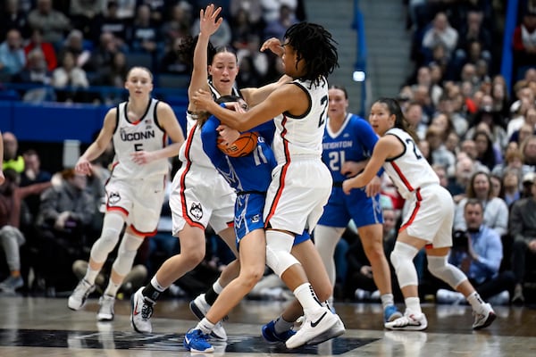 UConn guards Ashlynn Shade, left, and KK Arnold, right, pressure Creighton guard Kiani Lockett, center, in the first half of an NCAA college basketball game, Thursday, Feb. 27, 2025, in Hartford, Conn. (AP Photo/Jessica Hill)