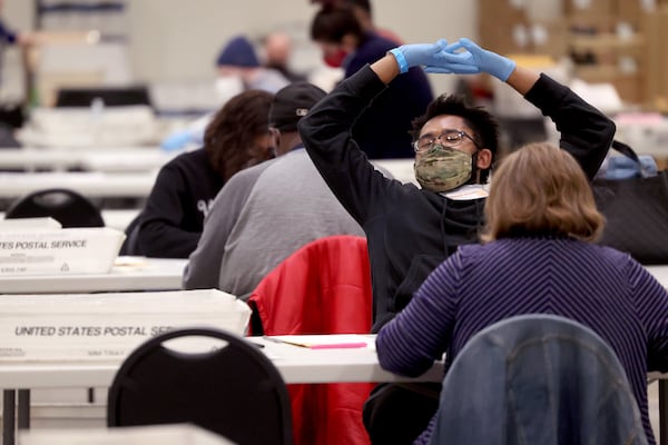 Nov. 3, 2020 - Marietta, Ga: Cobb County government election worker Cory Porter takes a break to stretch as he counts 2020 absentee ballots at Jim Miller Park Tuesday, November 3, 2020 in Marietta, Ga..  JASON GETZ FOR THE ATLANTA JOURNAL-CONSTITUTION



