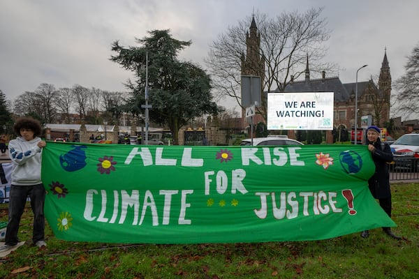 Activists protest outside the International Court of Justice, in The Hague, Netherlands, as it opens hearings into what countries worldwide are legally required to do to combat climate change and help vulnerable nations fight its devastating impact, Monday, Dec. 2, 2024. (AP Photo/Peter Dejong)