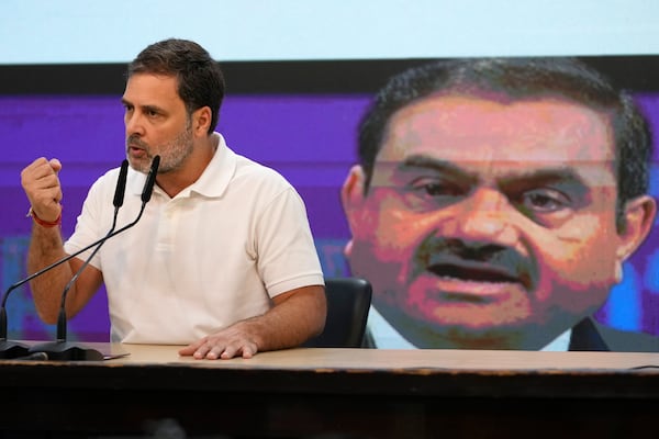 India's opposition Congress party leader Rahul Gandhi addresses the media on Indian businessman Gautam Adani, after Adani was indicted by U.S. prosecutors on charges he duped investors in a massive solar energy project in India, in New Delhi, India, Thursday, Nov. 21, 2024. Image behind shows Adani. (AP Photo/Manish Swarup)