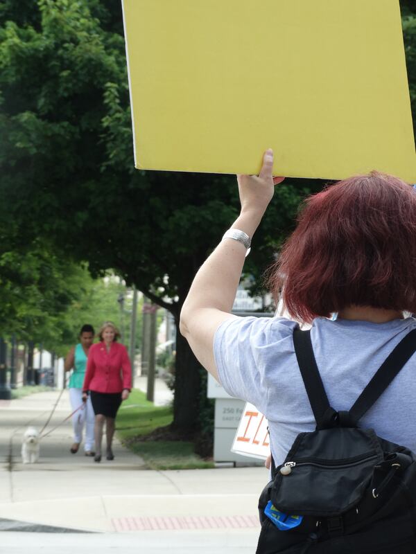 Protesters try to get Teya Ryan's attention outside GPB headquarters. CREDIT: Rodney Ho/rho@ajc.com