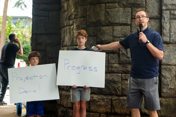 Charlie Copp (right), an educator in Atlanta Public Schools, speaks during a back-to-school rally for Georgia educators accompanied by his sons Charles Baxter Copp (left) and James Bennett Copp (center) on Saturday, July 23, 2022, at Piedmont Park in Atlanta. Teachers, community members and students gathered to speak against new state laws that limit classroom discussions about race and streamline the process for banning books in schools. (Christina Matacotta for The Atlanta Journal-Constitution) 