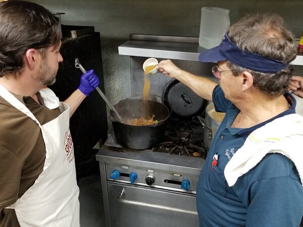 Spuddy Faucheux (right) of Spuddy’s Cajun Foods demonstrates how to season jambalaya. Contributed by Wesley K.H. Teo