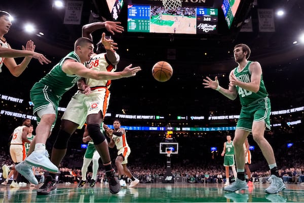 Boston Celtics guard Payton Pritchard, left, passes the ball to Luke Kornet (40) during the first half of an NBA basketball game against the Detroit Pistons, Wednesday, Dec. 4, 2024, in Boston. (AP Photo/Charles Krupa)