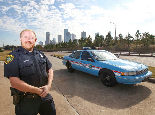 FILE - This Nov. 21, 2018 photo shows Houston police officer Jason Knox standing by a restored  HPD cruiser in Houston.  The Houston police department tweeted that Knox, a Tactical Flight Officer, was killed when a police helicopter crashed early Saturday, May 2, 2020 in Houston. (Steve Gonzales/Houston Chronicle via AP)