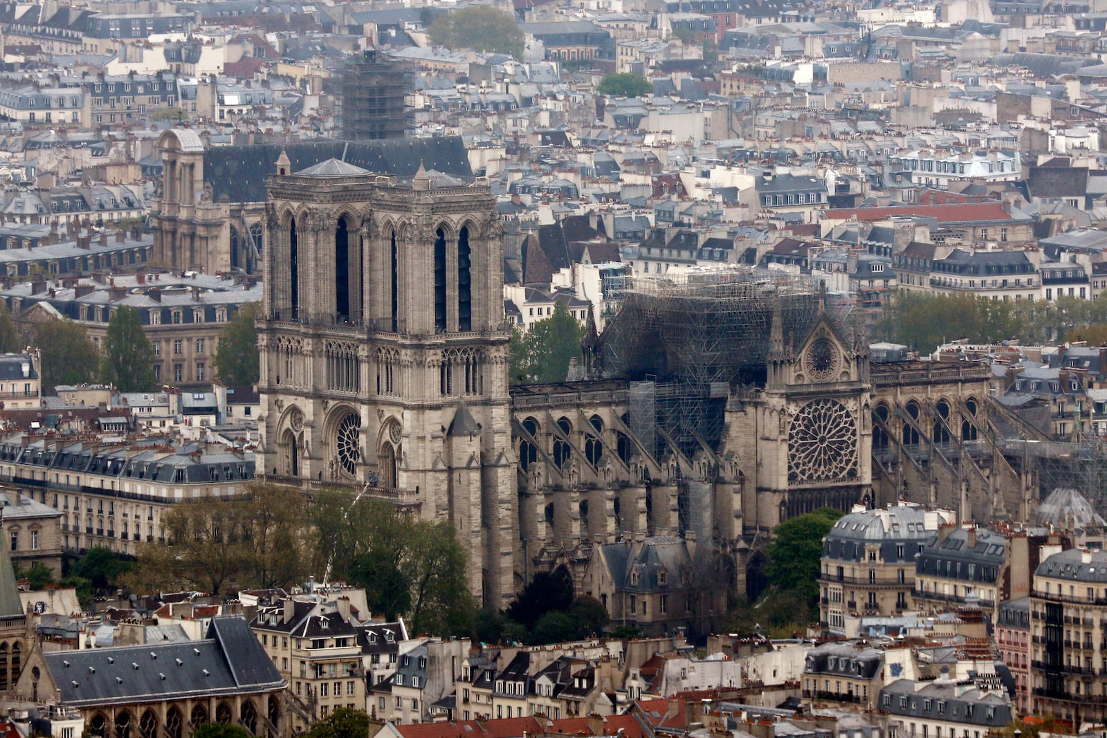 Notre Dame cathedral is pictured from the top of the Montparnasse tower, Tuesday April 16, 2019 in Paris. Firefighters declared success Tuesday morning in an over 12-hour battle to extinguish an inferno engulfing Paris' iconic Notre Dame cathedral that claimed its spire and roof, but spared its bell towers. (AP Photo/Thibault Camus)