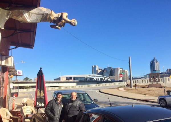 Mike Jakob (left) and his brother Pete, owners of the Elliot Street Deli and Pub, have a front-row panoramic view of what will be built in the Gulch, as does their mermaid. Photo by Bill Torpy