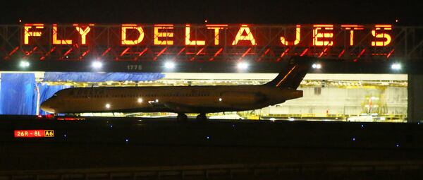 A Delta jet passes by the Delta maintenance hanger taking off from Hartsfield-Jackson Atlanta International Airport late at night on Monday, Sept. 30, 2013, in Atlanta.