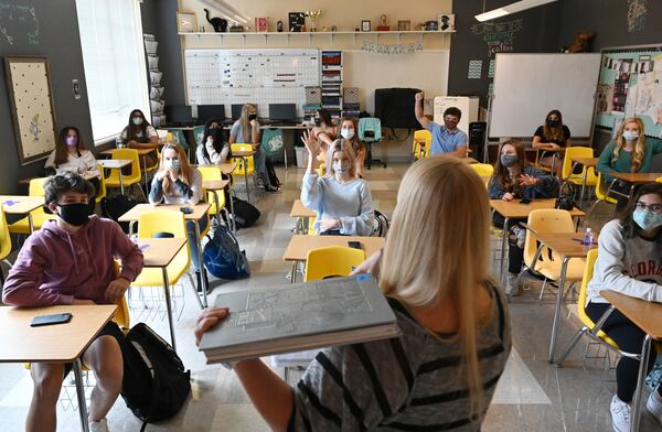 Jordan Kohanim (foregound) discusses with students about the school's 100th anniversary yearbook cover design at Milton High School on Oct. 15, 2020. (Hyosub Shin / Hyosub.Shin@ajc.com)