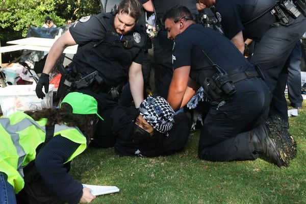 University of Georgia police officers hold a woman down as they arrest her for charges of "criminal trespassing" during a demonstration at the lawn in front of Old College on UGA's campus in Athens, Georgia, on Monday, April 29, 2024. Her and other students are pro-Palestinian demonstrators and have joined hundreds of college students across the United States in a nation-wide movement. (Photo Courtesy of Liz Rymarev)