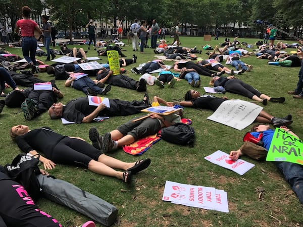 Protesters held a "die-in" at Woodruff Park as President Donald Trump headed Friday to Atlanta to speak to the National Rifle Association annual convention.