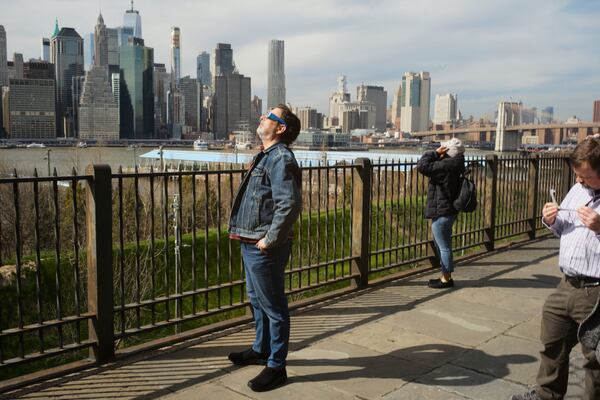 People gather to watch the partial solar eclipse in Brooklyn, N.Y. on Monday, April 8, 2024. (Photo Courtesy of David Sassoon/Inside Climate News)