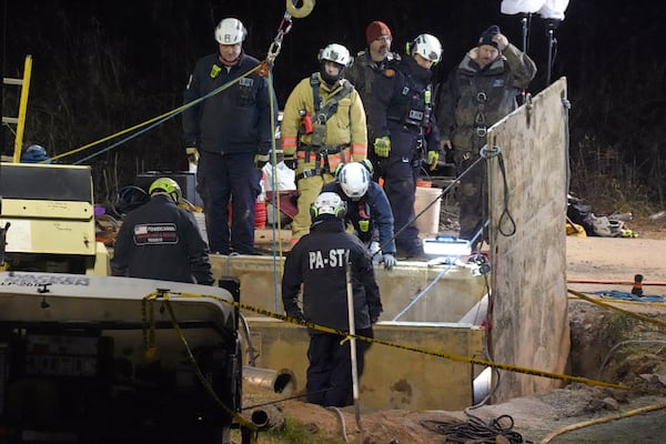 Rescue workers search through the night in a sinkhole for Elizabeth Pollard, who disappeared while looking for her cat, in Marguerite, Pa., Tuesday, Dec. 3, 2024. (AP Photo/Gene J. Puskar)