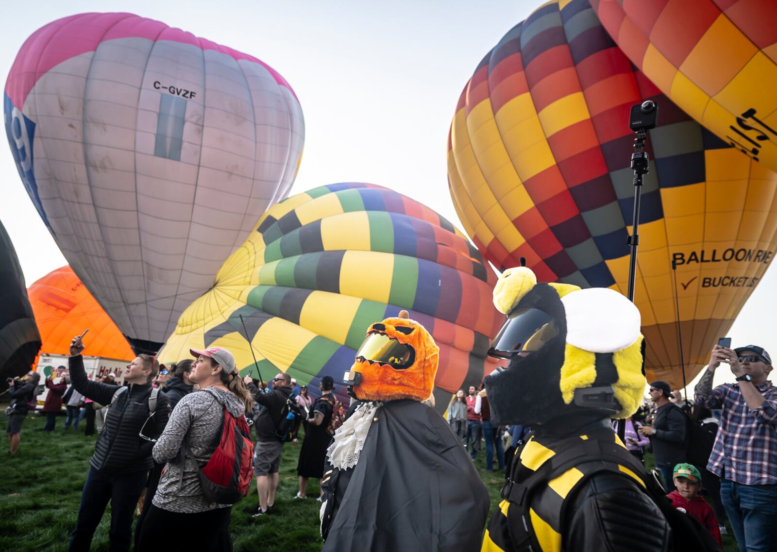 Matt Ramos, center, and his girlfriend Alana Mariah of Albuquerque broadcast a live video stream while wearing costumes during the mass ascension at the 52nd Albuquerque International Balloon Fiesta in Albuquerque, N.M., on Saturday, Oct. 5, 2024. (AP Photo/Roberto E. Rosales)