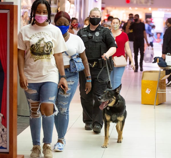 K9 Handler Stephanie Bong walks through the Perimeter Mall with her German Shepherd trained in weapons detection Friday, March 9, 2021. STEVE SCHAEFER FOR THE ATLANTA JOURNAL-CONSTITUTION