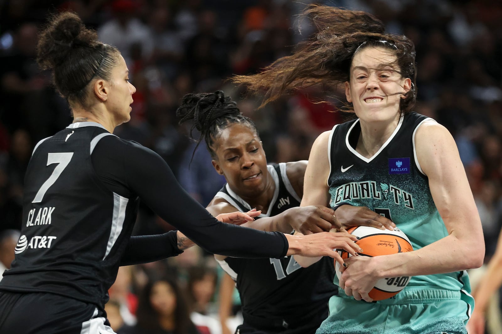 New York Liberty forward Breanna Stewart (30) wrestles a rebound away from Las Vegas Aces forward Alysha Clark (7) and guard Chelsea Gray (12) during the second half of a WNBA Semifinal basketball game Sunday, Oct. 6, 2024, in Las Vegas. (AP Photo/Ian Maule)