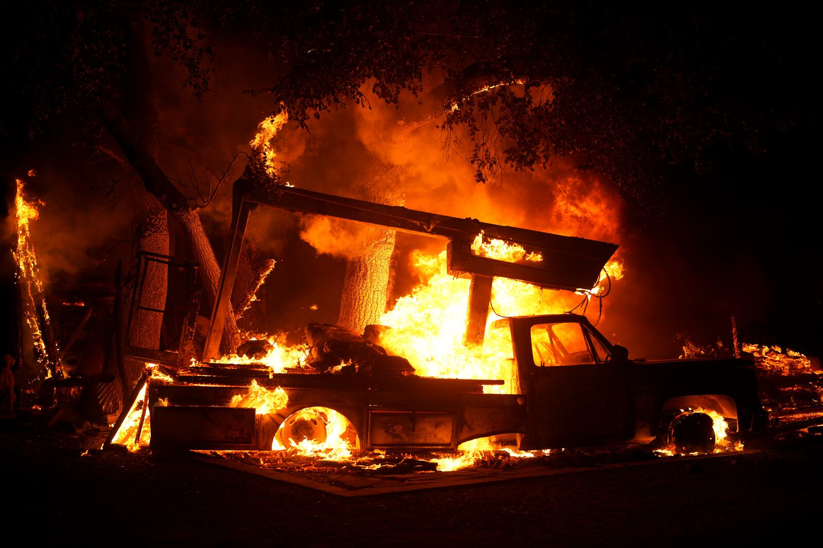 A vehicle burns from the Airport Fire Tuesday, Sept. 10, 2024, in El Cariso, an unincorporated community in Riverside County, Calif. (AP Photo/Eric Thayer)