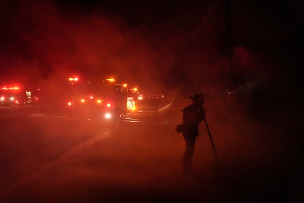 A firefighter watches the Franklin Fire as smoke fills the air in Malibu, Calif., Tuesday, Dec. 10, 2024. (AP Photo/Jae C. Hong)