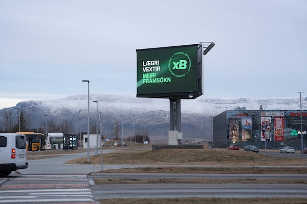 A bilboard of the Progressive Party (Framsóknarflokkurinn) reading "Lower interest rates - More Progress", is backdropped by Mt. Esja covered with fresh snow in Reykjavik, Iceland, Friday, Nov. 29, 2024. (AP Photo Marco Di Marco)