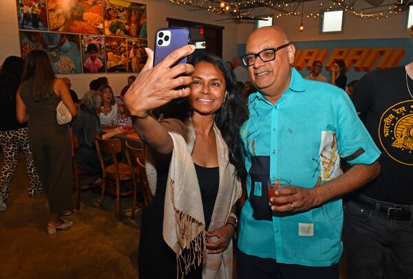 A thrilled guest gets a selfie with chef and author Vishwesh Bhatt during an Aug. 9, 2022, event at Chai Pani in downtown Decatur to celebrate Bhatt's newly released cookbook, ”I Am From Here: Stories and Recipes From a Southern Chef." (Chris Hunt for the AJC)