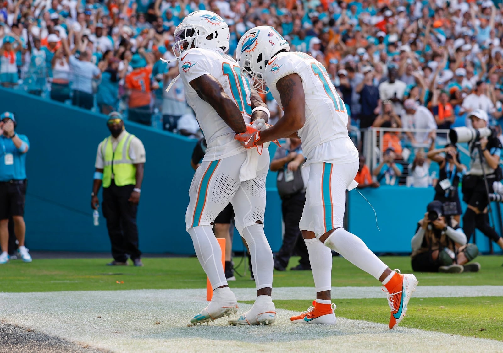 Miami Dolphins wide receiver Tyreek Hill (10) holds his hands behind his back as if he is handcuffed as Miami Dolphins wide receiver Jaylen Waddle (17) unlocks them after Hill scores against the Jacksonville Jaguars in the second half during an NFL football game at Hard Rock Stadium in Miami Gardens, Florida, on Sunday, Sept. 8, 2024. (Al Diaz/Miami Herald via AP)