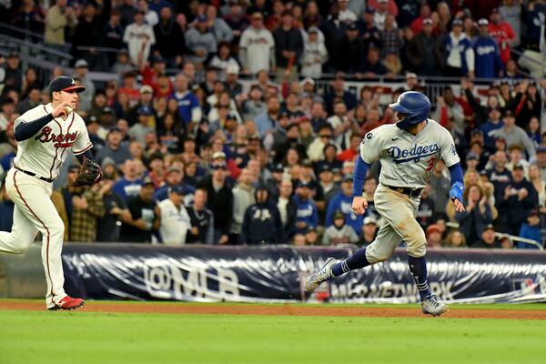 Dodgers center fielder Chris Taylor, right, gets caught in a run down by the Braves during the ninth inning.  Hyosub Shin / Hyosub.Shin@ajc.com 