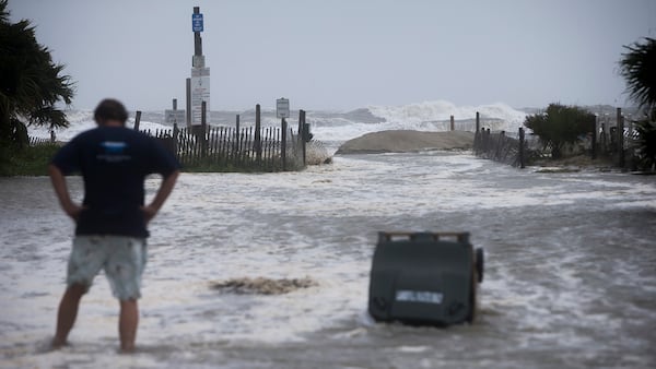 Part of a temporary berm put up to stop the storm surge from Tropical Storm Irma breaks apart and floods the street, Monday, Sept., 11, 2017 on of Tybee Island, Ga. (AP Photo/Stephen B. Morton)