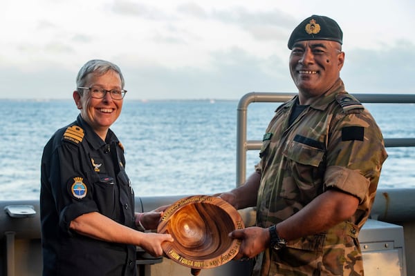 FILE - In this undated photo provided by the New Zealand Defence Force, Lieutenant Commander Tala Mafile'o of the Royal Tongan Navy presents Commander Yvonne Gray, left, with a carved wooden bowl as a memento of the RNZN's participation in the 50th Anniversary Fleet Review. (New Zealand Defence Force via AP,File)