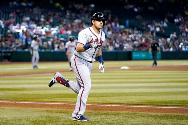 Atlanta Braves' Austin Riley points to teammates in the dugout after hitting a three-run home run against the Arizona Diamondbacks during the seventh inning of a baseball game Wednesday, June 1, 2022, in Phoenix. (AP Photo/Ross D. Franklin)