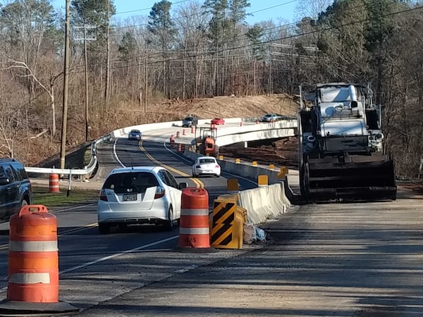 Paving is under way on the roadway approaching the bridge. The new section is to the right of the temporary concrete barrier in this photo, taken from the Cherokee County side of the bridge. (Brian O'Shea, bposhea@ajc.com)