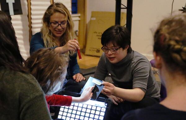 Martha, right, holds a screw with as a student runs his fingers over it as part of a lesson at the Ellis Center in Decatur. EMILY HANEY / emily.haney@ajc.com