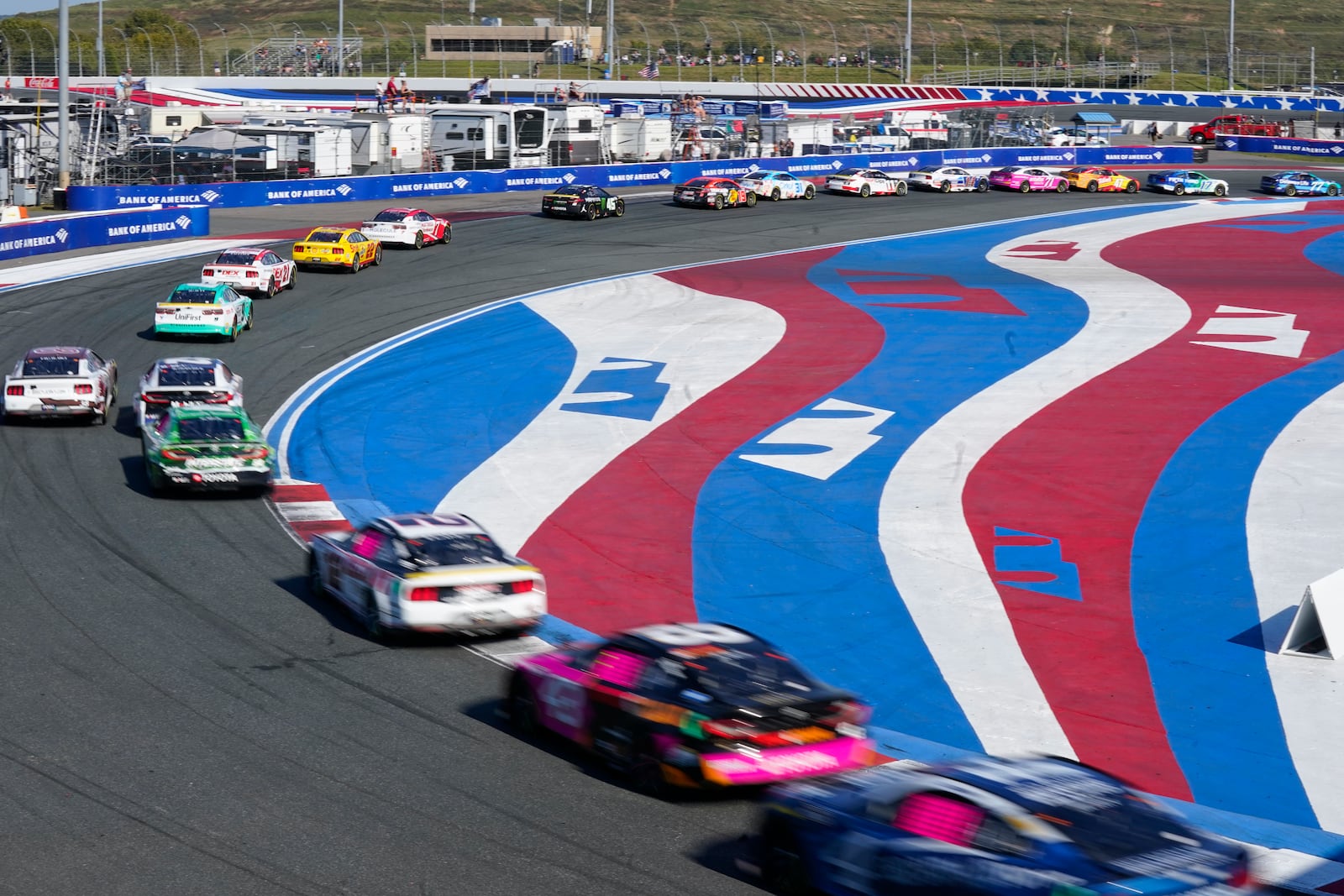 Drivers take their cars through Turn 3 during a NASCAR Cup Series auto race at Charlotte Motor Speedway in Concord, N.C., Sunday, Oct. 13, 2024. (AP Photo/Chuck Burton)