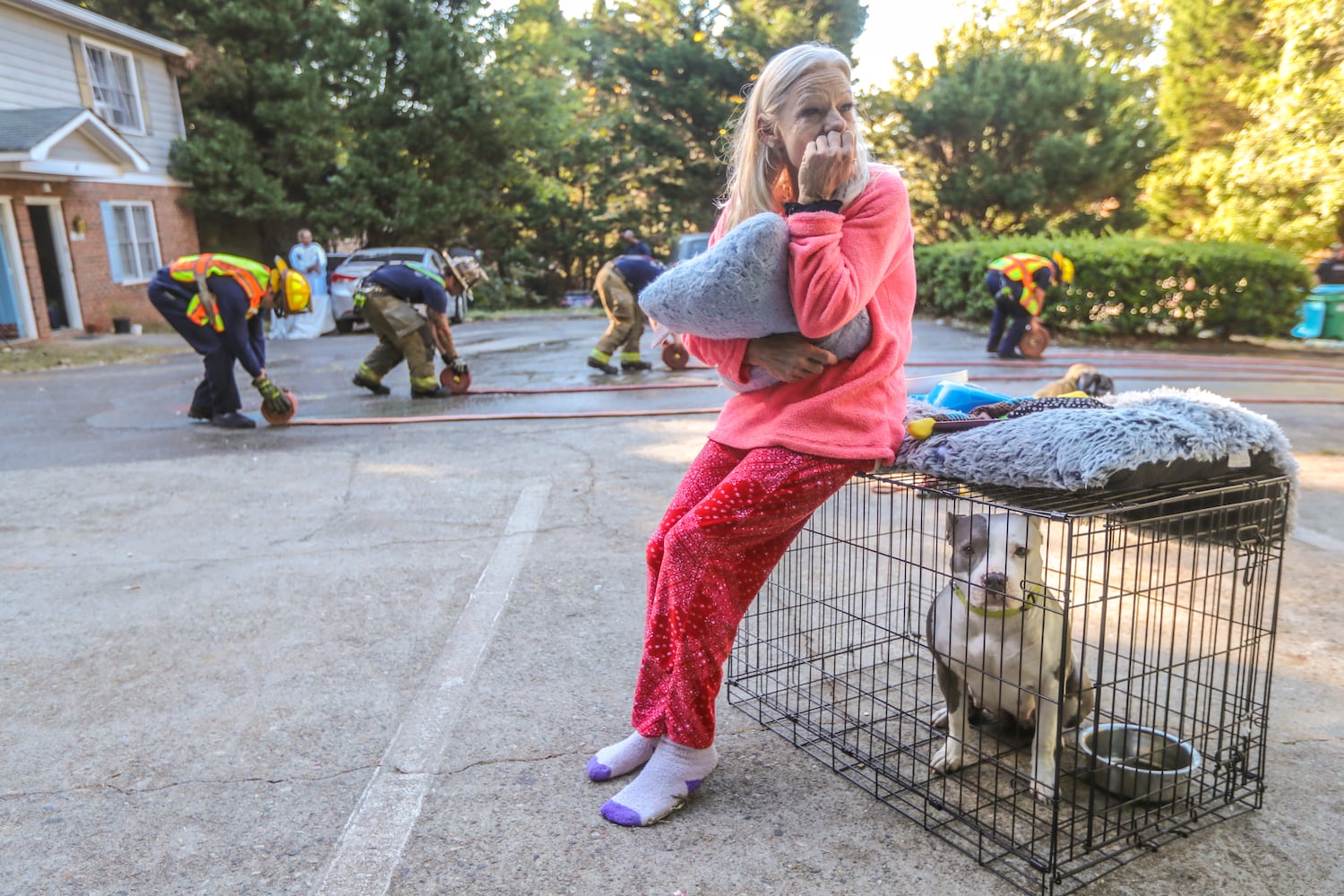 Pauline Bush sits with one of the pets she was taking care of while house-sitting Thursday morning when a fire broke out. Bush was asleep and had to be awakened by firefighters when the smoke detector did not go off.
