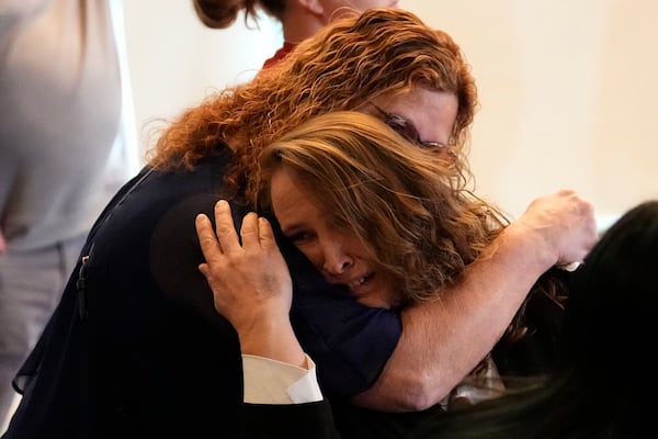 Charlene Slaugh is comforted after talking to the media during a news conference where survivors and family members of victims from the Club Q nightclub mass shooting in Colorado Springs, Colo., announced the filing of a civil complaint on the two-year anniversary of the deadly mass shooting, Tuesday, Nov. 19, 2024, in Denver. (AP Photo/Jack Dempsey)