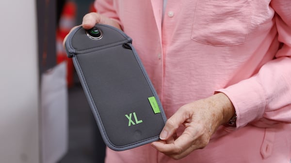 Several schools in Atlanta require students to lock their cellphones and smartwatches in pouches during the school day so they aren't able to access them. Midtown High School Principal Betsy Bockman holds up a Yondr pouch, which have been purchased in several school systems this year. (Natrice Miller/AJC 2024)