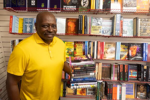 Curtis Bunn poses for a portrait with the books he authored  at Medu Bookstore at Greenbriar Mall on July 11, 2023 in Atlanta. Bunn, founder of The National Book Club Conference, is preparing his annual conference in July. (Michael Blackshire/Michael.blackshire@ajc.com)