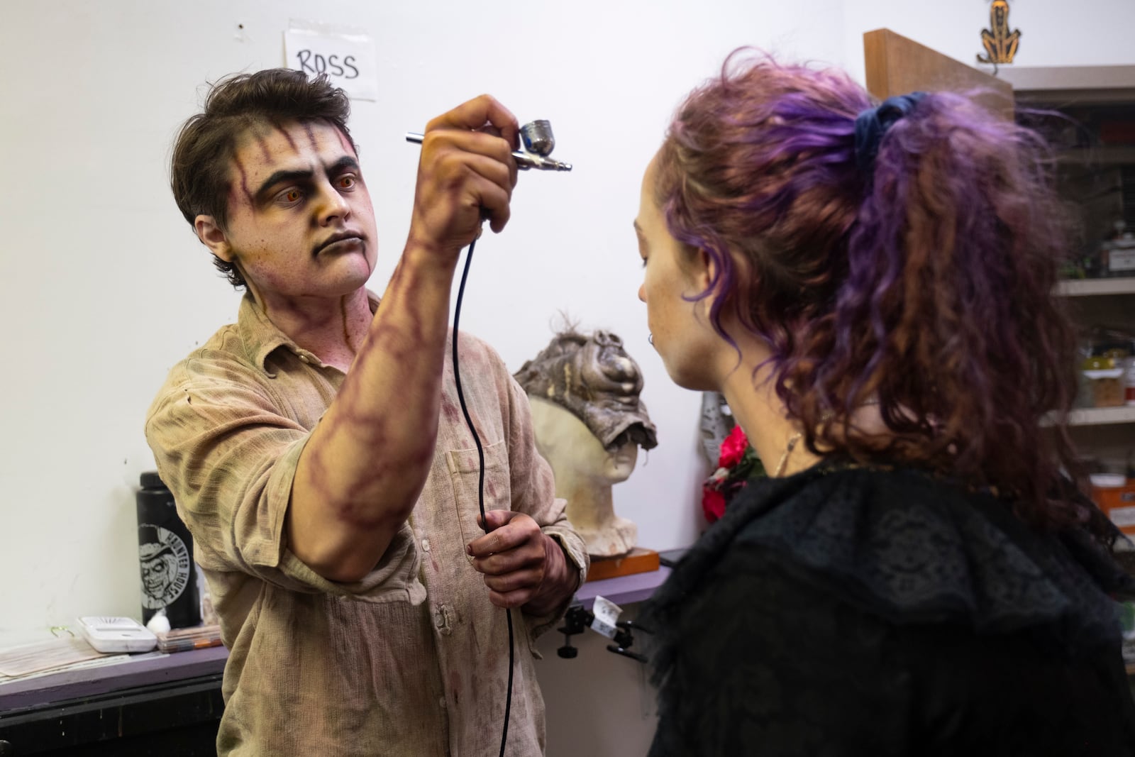 Alex Ross paints an actor’s face before the doors open at Netherworld haunted house in Stone Mountain on Friday, Oct. 25, 2024.   Ben Gray for the Atlanta Journal-Constitution