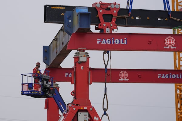 A worker moves up to a gantry crane assembly at Entergy's Orange County Advanced Power Station, a 1,215-megawatt facility under construction on Feb. 24, 2025, in Orange, Texas. (AP Photo/David J. Phillip)