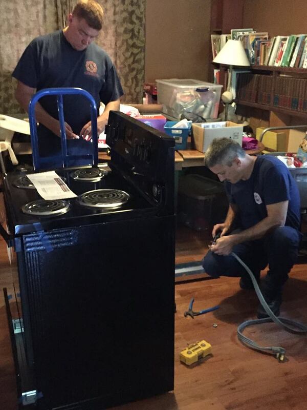 Two Alpharetta firefighters install new appliances inside the home of Nell and Joe Estes on Monday, Oct. 24. Alpharetta public safety officials spent multiple days renovating the home on Sherry Lane, where 11-month-old Raven Raines and her family lives.