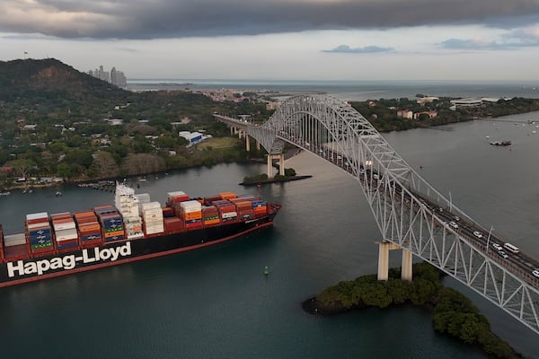 A cargo ship sails under Las Americas bridge through the Panama Canal, in Panama City, Thursday, March 13, 2025. (AP Photo/Matias Delacroix)