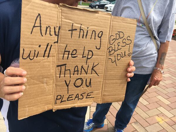 Coreana Hermann shows the sign she was holding at the intersection of Stewart Street and Patterson Boulevard. She said she just moved here from Florida and is trying to get on her feet.