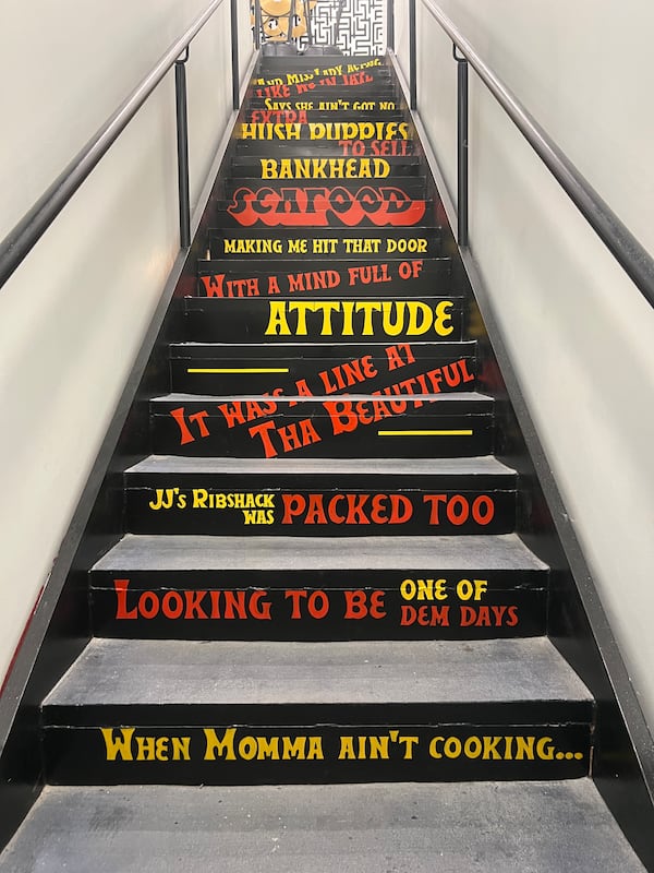 The staircase leading up to Bankhead Seafood's rooftop deck features painted lyrics from Goodie Mob's 1995 rap song "Soul Food," which reference the restaurant. (Mike Jordan/AJC)