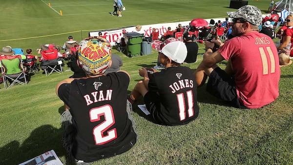 Jim Caldwell of Cumming and his sons Judson (left) and Nathan watch the first day of Falcons training camp in 2016 from the hill in Flowery Branch.