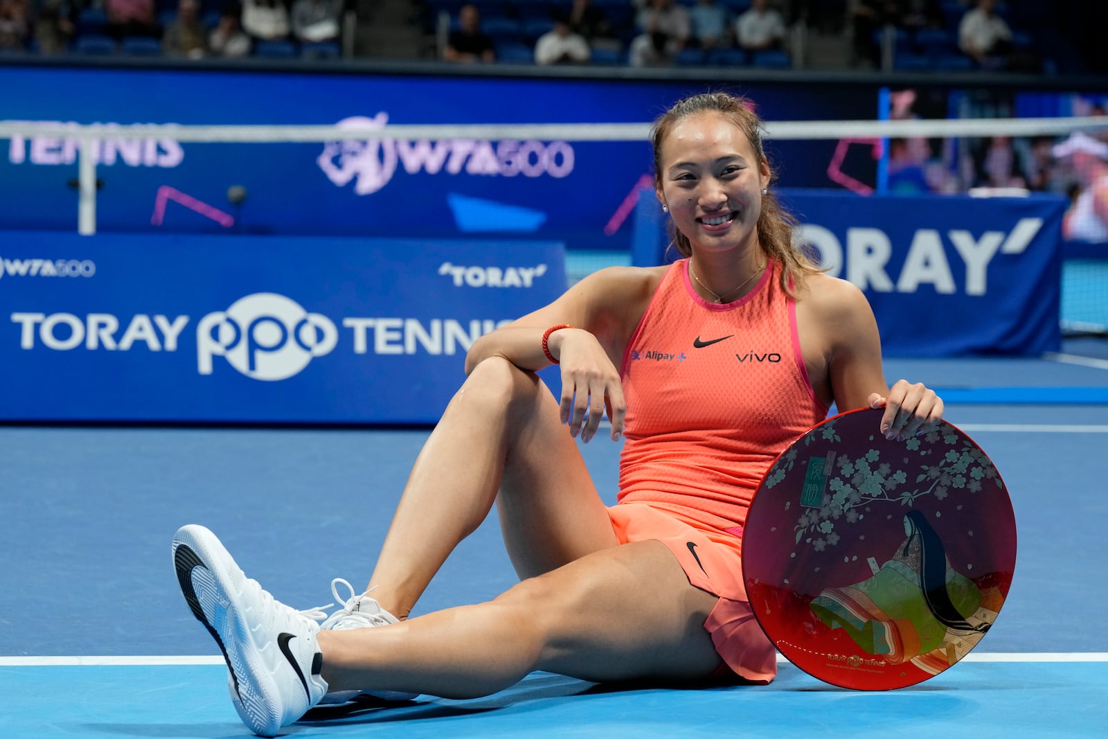 China's Zheng Qinwen poses with her trophy after winning the Pan Pacific Open women's tennis tournament at Ariake Coliseum, in Tokyo, Sunday, Oct. 27, 2024. (AP Photo/Eugene Hoshiko)