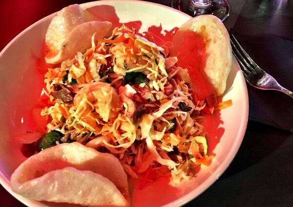 The neon lights at Co give everything, including this papaya salad made with cabbage, a red glow. CONTRIBUTED BY WYATT WILLIAMS