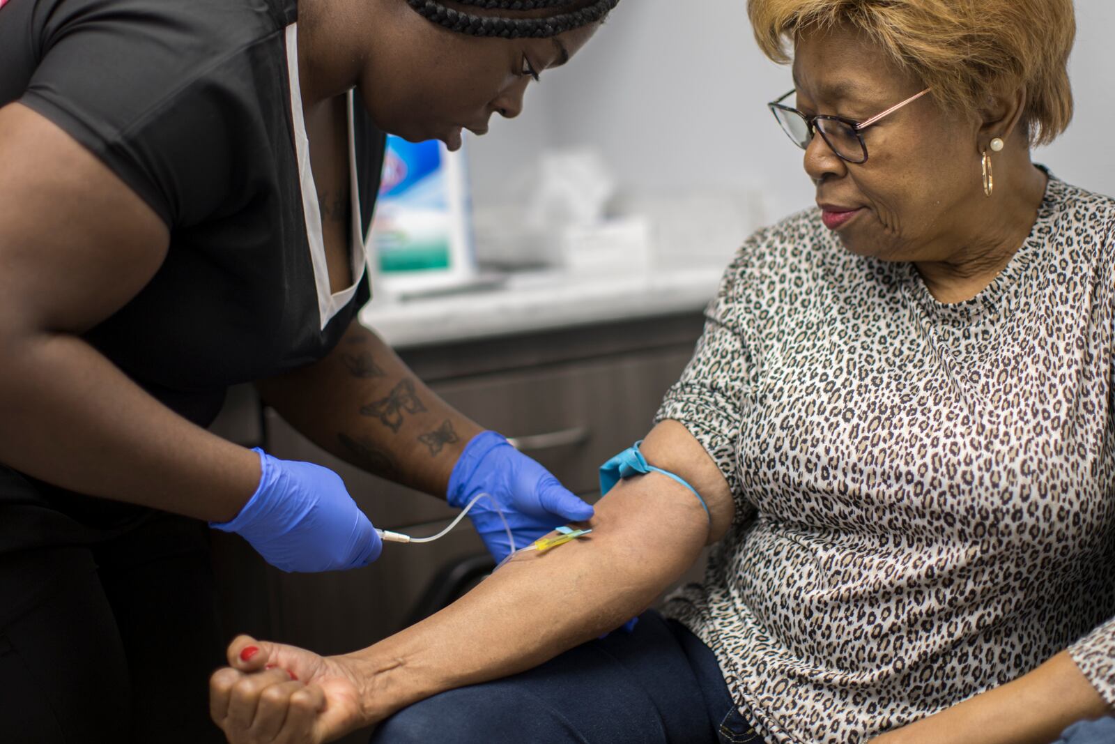 BRUNSWICK, GA - JANUARY 16, 2024: A phlebotomist working with Emory University, left, takes a  blood sample from Brunswick resident Etta Brown, right, as part of a study by the college into potential long-term health effects of exposure to chemicals present in Superfund sites around the Brunswick area. The Emory researchers are analyzing blood samples for contaminants including lead, mercury, arsenic, cadmium, and PCBs. (AJC Photo/Stephen B. Morton)